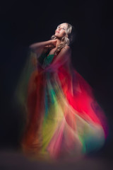 Model in colorful dress on black background
