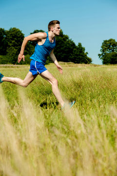 Young man running through meadows