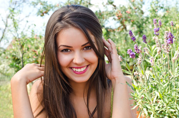 Beautiful woman in the garden with  a bouquet of lavender