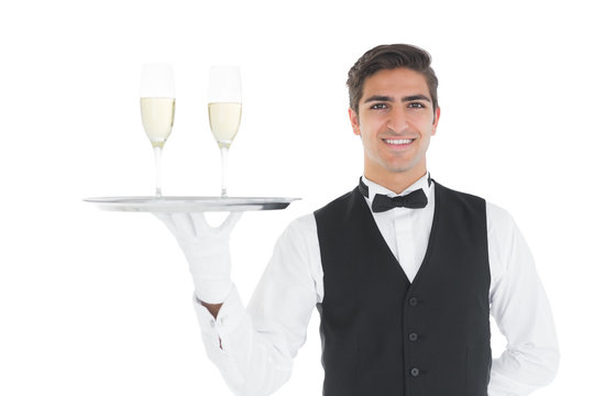 Smiling attractive holding a tray with champagne glasses on it