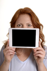 Hübsche rothaarige Frau hält Mini Tablet PC vors Gesicht - 56818151