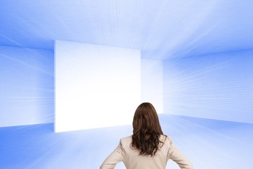 Businesswoman standing back to camera hands on hips