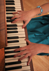 Dłonie pianistki na klawiszach pianina