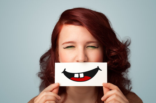 Happy pretty woman holding card with funny smiley