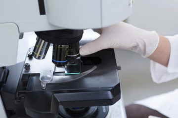 Scientist's hand zooming on a sample