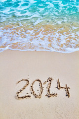 New 2014 year figures written on the sand