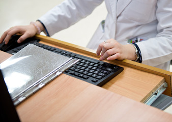 medical worker typing on computer.