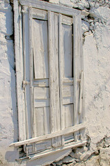 Wooden door painted white in stony wall
