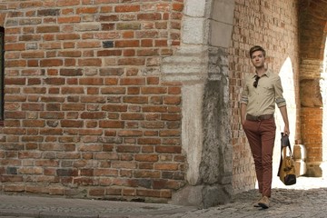 Young man with bag on street, old town Gdansk