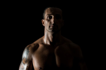 Fototapeta na wymiar Muscular man in a black background