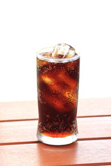 glass of cola with ice with copy-space in composition.