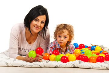 Mother and son lying bed with balls
