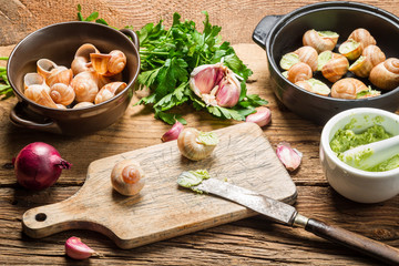 Closeup of preparing snails with garlic butter and herbs