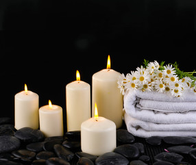 Obraz na płótnie Canvas candles on towel, cherry blossoms flower on pebbles