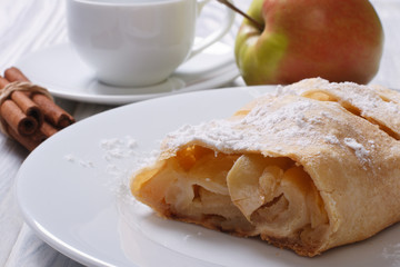 Apple pie with cinnamon on the white plate closeup