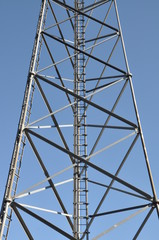Construction of tower with ladder against blue sky