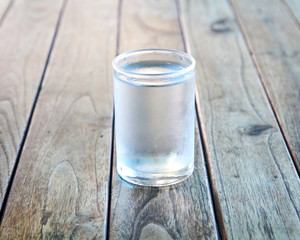 Glass of water on a wooden floor.