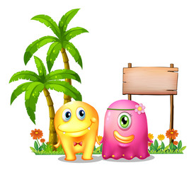 A yellow and a pink monster couple standing in front of the empt