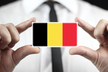 Businessman holding a business card with a Belgium Flag - obrazy, fototapety, plakaty