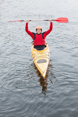 Happy man in a kayak cheering at camera