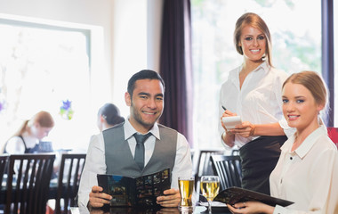 Business people and waitress smiling at camera