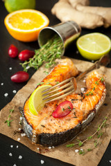 Baked fish salmon with lemon and thyme on the chalkboard