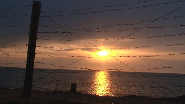 sunset behind barbed wire