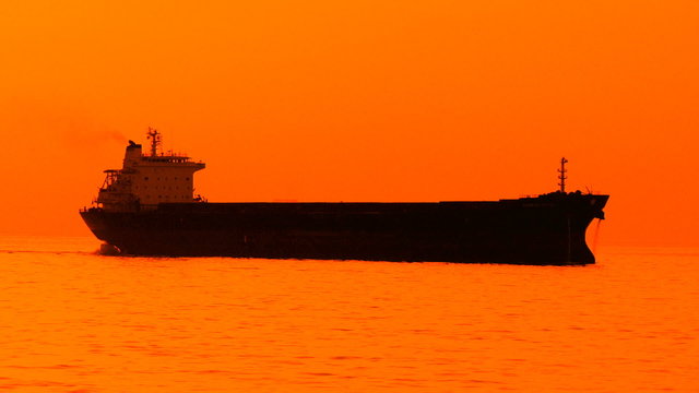 Cargo ship in the sea at sunset
