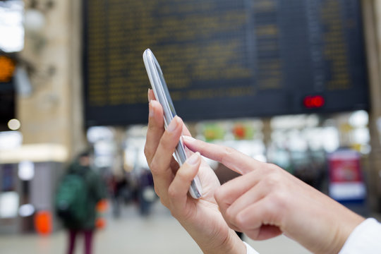 Close up of hands woman using her cell phone in train station, b