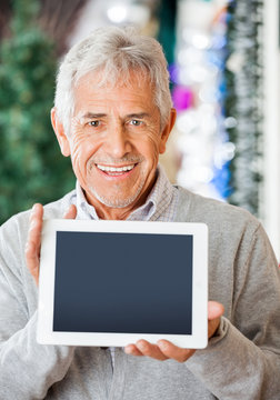 Happy Man Displaying Digital Tablet In Christmas Store