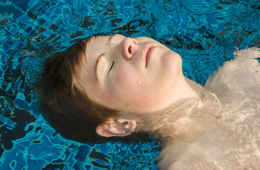 boy enjoys floating on his back