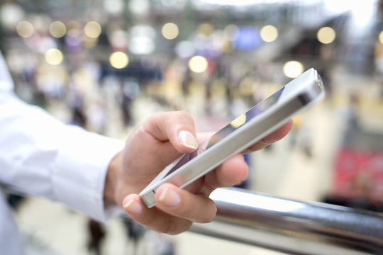 Close up of hands woman using her cell phone in station, backgro