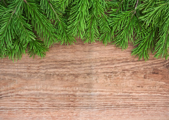 Christmas background: fir-tree branches on old wooden background