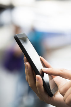 Close up of hands woman using her cell phone at a train station