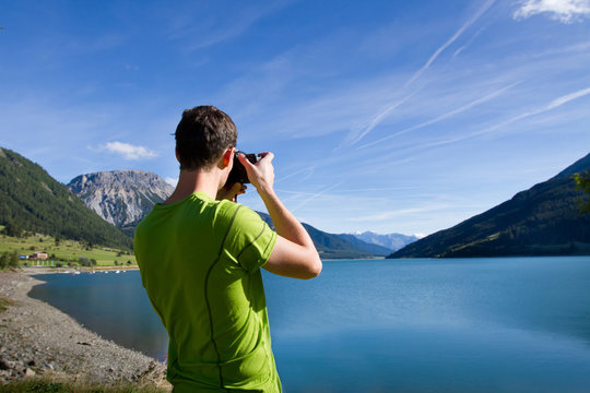 nature photographer near lake in mountains