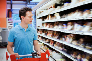 young attractive man choosing food in the supermarket