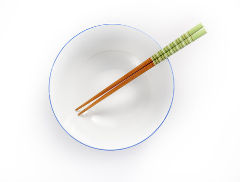 Chopsticks In Empty Bowl Isolated On A White Background