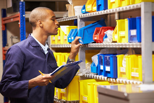 Worker Checking Stock Levels In Store Room