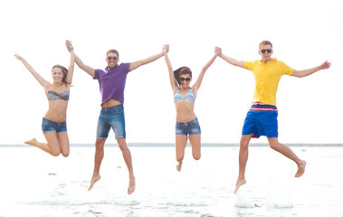 Obraz premium group of friends or couples jumping on the beach