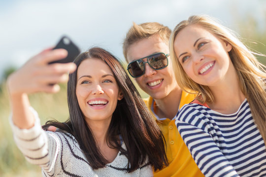 group of friends taking picture with smartphone