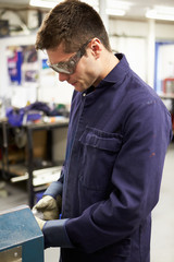 Apprentice Engineer Working On Factory Floor