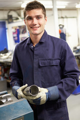 Apprentice Engineer Working On Factory Floor