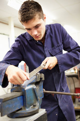 Apprentice Engineer Working On Factory Floor