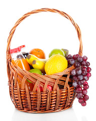 Different fruits in wicker basket with juice isolated on white