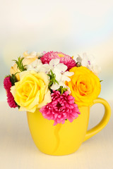 Beautiful bouquet of bright flowers in color mug,