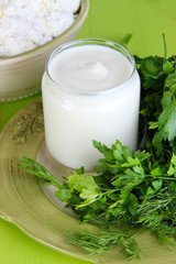 Obraz na płótnie Canvas Fresh yogurt with greens on wooden table on natural background