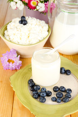 Fresh dairy products with blueberry on wooden table close-up