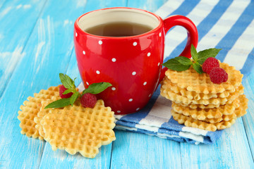 Cup of tea with cookies and raspberries on table close-up