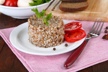 Buckwheat in plate with bread and vegetables closeup