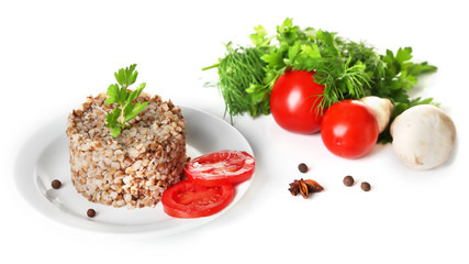 Buckwheat in plate and vegetables isolated on white
